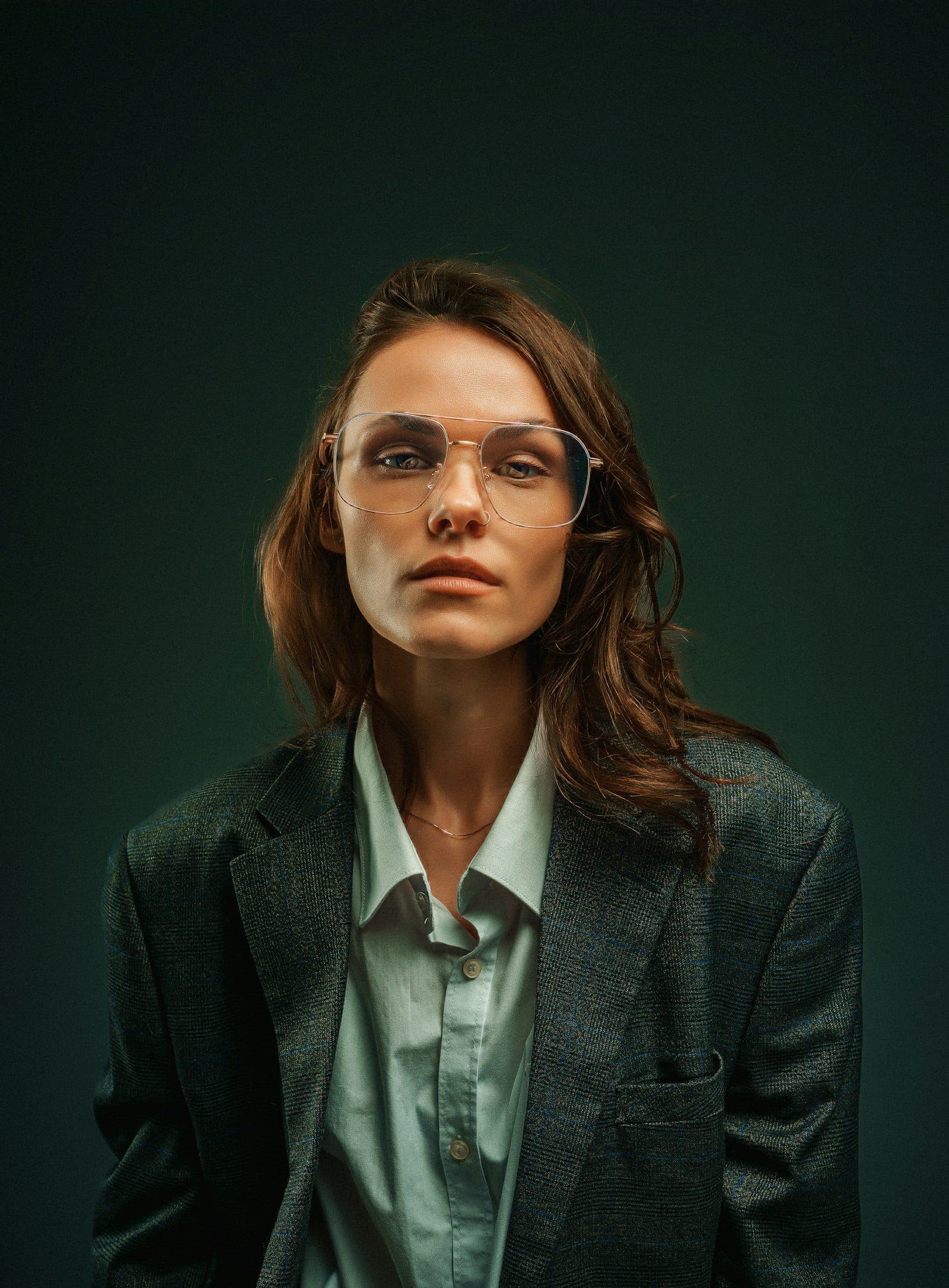 Woman in clear round eyeglasses and a tailored jacket